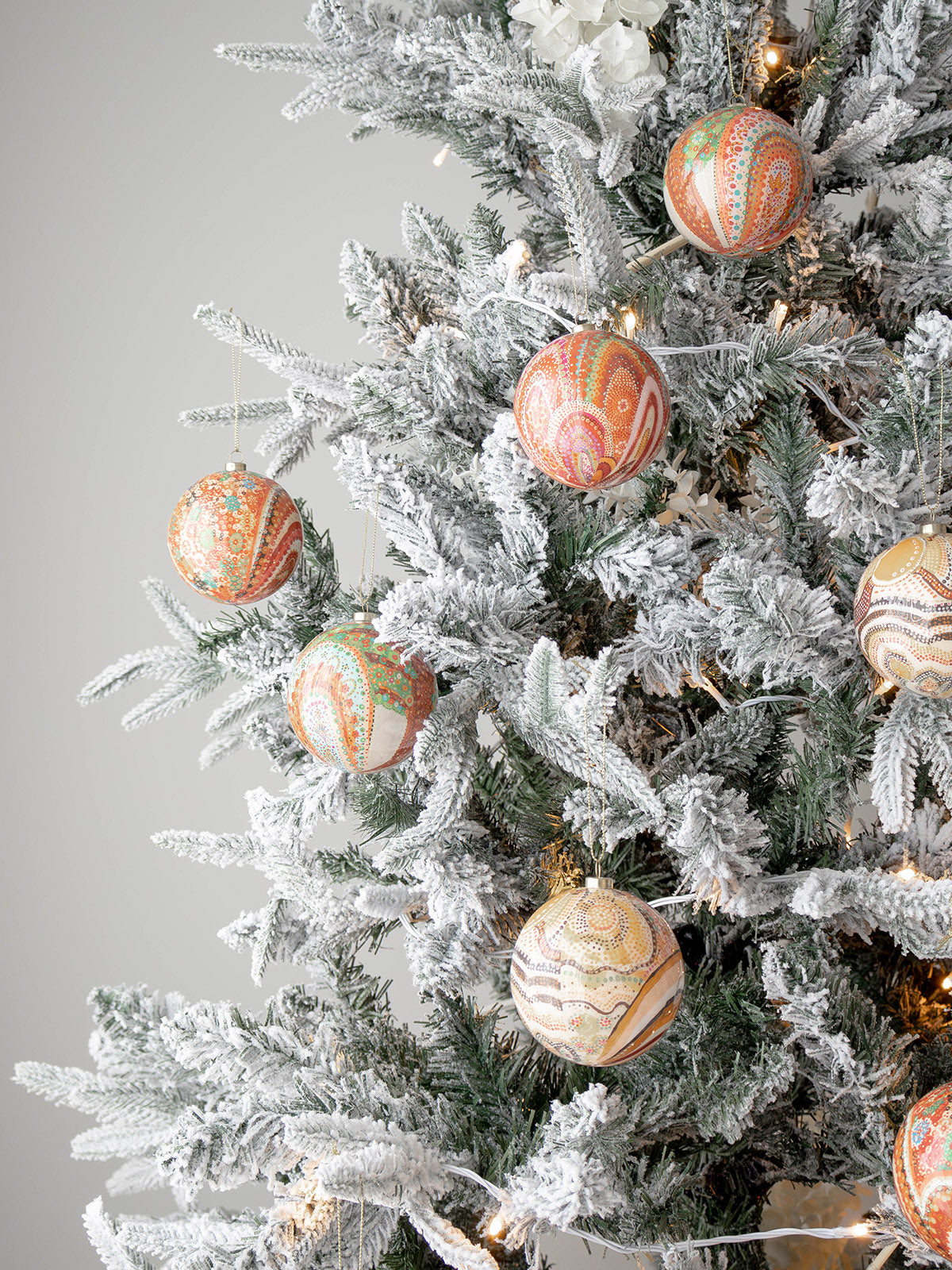 Koh Living Aboriginal Xmas Baubles in Beautiful Journey design hanging on tree